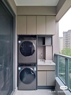 a washer and dryer in a small room next to an open window with city view