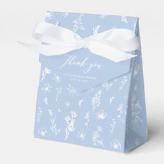 a blue gift bag with white flowers on it