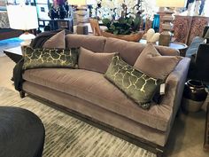 a living room filled with lots of furniture and pillows on top of a rug in front of a couch