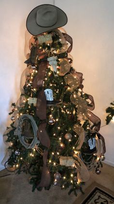 a christmas tree decorated with cowboy hats and ribbons