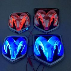 four lights that are shaped like rams on the side of a car with red, white and blue tail lights