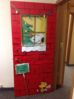 a door decorated to look like a christmas tree with a snoopy window on it