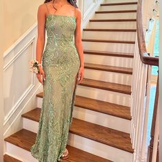 a woman standing in front of some stairs wearing a dress with sequins on it