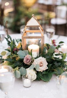 a table with candles and flowers on it is set up for an outdoor wedding reception