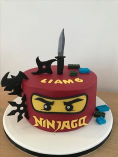 a lego ninja cake on a plate with a knife stuck in it's face