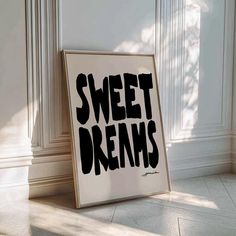 a black and white poster with the words sweet dreams on it in front of a wall