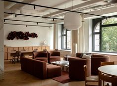 a living room filled with lots of furniture and large windows next to a wooden floor