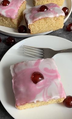 a piece of cake with cherries on it and a fork next to the plate