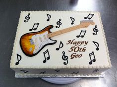 a birthday cake with a guitar and musical notes on the side that says happy 50th go