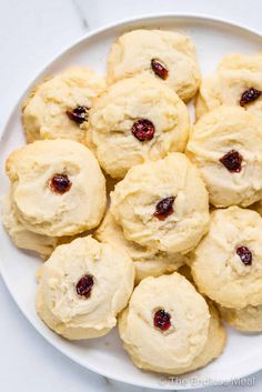 a white plate filled with cookies covered in cranberry filling on top of a table