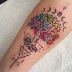 a colorful tattoo on the leg of a woman's arm with an eagle and tree