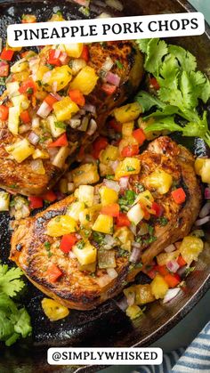 pineapple pork chops in a cast iron skillet topped with chopped vegetables and cilantro