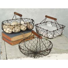 two wire baskets with bread in them sitting on top of a wooden table next to an open book