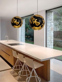 two lamps hanging from the ceiling above a kitchen island