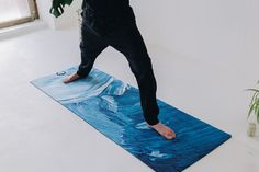 a person standing on a yoga mat in front of a window