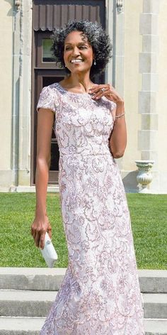 a woman in a pink dress is walking down the street with her hand on her hip