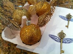 some golden ornaments are sitting on a table with gold key holders and keys in front of them