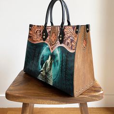 a handbag with an image of a wolf on it sitting on a wooden bench