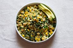 a white bowl filled with corn and avocado