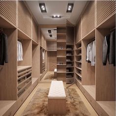 a large walk in closet with wooden shelves and drawers