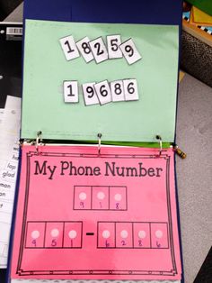 a phone number game is displayed on a desk with papers and pencils next to it