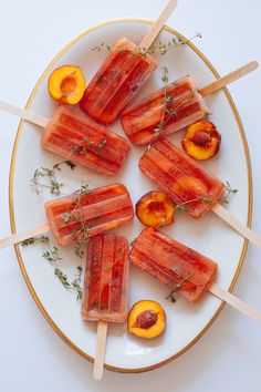 popsicles with peaches and herbs on a white plate