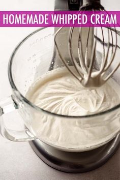 a whisk in a glass bowl filled with whipped cream