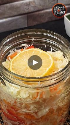 a glass jar filled with food sitting on top of a table next to a bowl