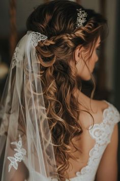 a bride with her hair in a half - up braid wearing a wedding dress and veil