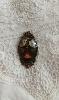 "With rich color and exquisite clarity, encased in an antiqued Victorian bronze toned setting our fine art witches brooch measures 2.25 inches in length. The Victorian artwork is set under a high quality glass dome.  Every item in our shop is handmade and created with loving care. For your timeless style!  Please note: The glare on the cameo occurs from the photo and is not a blemish on the piece. Our cameos are resistant but not waterproof and should not be submerged in water or worn when swimming or bathing. \"Each time you happen to me all over again!\" ~The Age of Innocence Your jewelry arrives in a white jewelry box tucked inside a lovely organza bag, ready for gift giving. If your order is being sent directly to a gift recipient, we are delighted to take part in your thoughtfulness a Gothic Halloween Brooch Jewelry, Halloween Gothic Brooch Jewelry, Gothic Brooch Jewelry Gift, Vintage Halloween Jewelry Gift, Vintage Halloween Costume Jewelry, Gothic Halloween Brooches For Gift, Handmade Brooches For Halloween Gift, Halloween Brooch Jewelry Gift, Halloween Gift Jewelry Brooch