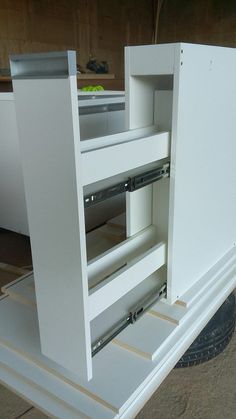 an open white cabinet sitting on top of a flatbed truck's side door