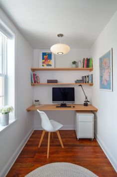 a white chair sitting in front of a computer desk on top of a hard wood floor