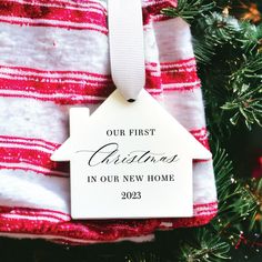 a christmas ornament hanging from a tree with red and white striped fabric on it