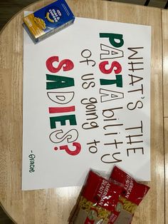 a wooden table with a sign on it that says sale and two bags of chips