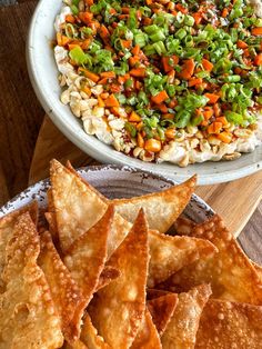 some food is sitting on a plate next to a bowl of rice and other foods