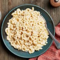 a bowl of macaroni and cheese on a wooden table