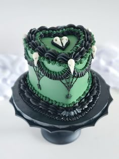 a green and black cake sitting on top of a table