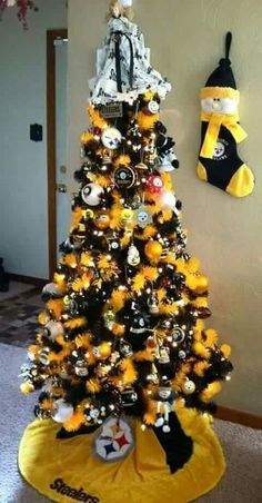 a yellow christmas tree decorated with black and white football ornaments is in the corner of a room