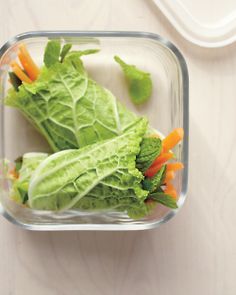 some lettuce and carrots in a glass container