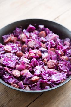 kielbasa and cabbage skillet dinner in a pan on top of a wooden table