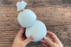 a person holding an onion on top of a wooden table