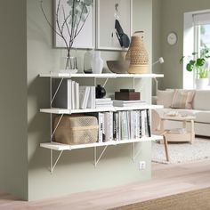 a living room filled with furniture next to a white book shelf covered in books and magazines