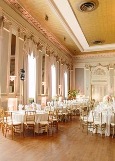 a room filled with tables and chairs covered in white tablecloths