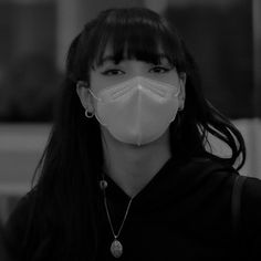 a woman wearing a face mask in black and white