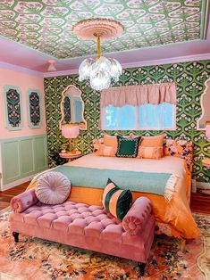 a bedroom decorated in pink, green and gold with a large bed on top of a rug