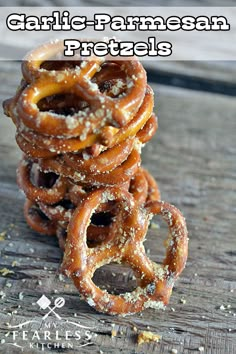 a stack of pretzels sitting on top of a wooden table with the words garlic and parmesan pretzels