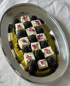 there are many pieces of cake on the plate with blackberries and raspberries