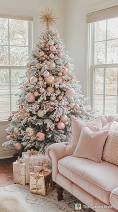 a white christmas tree with pink and gold ornaments in the corner of a living room