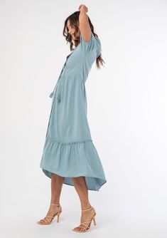 Ultra-relaxed and flowy, this cool bohemian midi dress is designed in a linen-blend. Featuring short puff sleeves, a self-covered button front, and a ruffle-trimmed tiered skirt for added shape and movement. Worn here with the Alohas Dune Block Heel Sandals. Linen blend Relaxed, flowy fit Short puff sleeves Elastic cuff Mid-length Ruffle-trimmed tiered skirt Split v-neckline with tassel ties Self-covered button front Flowy bohemian dress Model is 5'9, wearing a size S.Style: I-72742W-RJX Breezy Short Sleeve Midi Dress For Spring, Flowy Linen Dress With Short Sleeves For Vacation, Short Sleeve Midi Dress With Ruffle Hem For Daywear, Spring Tiered Linen Midi Dress, Summer Linen Dress With Ruffles And Short Sleeves, Short Sleeve Rayon Dress With Ruffle Hem, Flowy Short Sleeve Midi Dress In Breezy Style, Linen Midi Dress With Ruffle Hem, Flowy Breezy Midi Dress With Short Sleeves