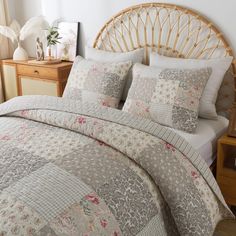 a bed with a white comforter and pillows on top of it, next to a wooden headboard